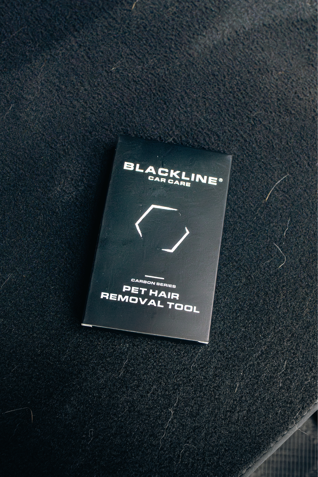 BLACKLINE pet hair brush packaging on a dark fabric surface